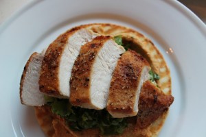 Place dressed lettuce on top of hummus in a small mound. Add sliced chicken.